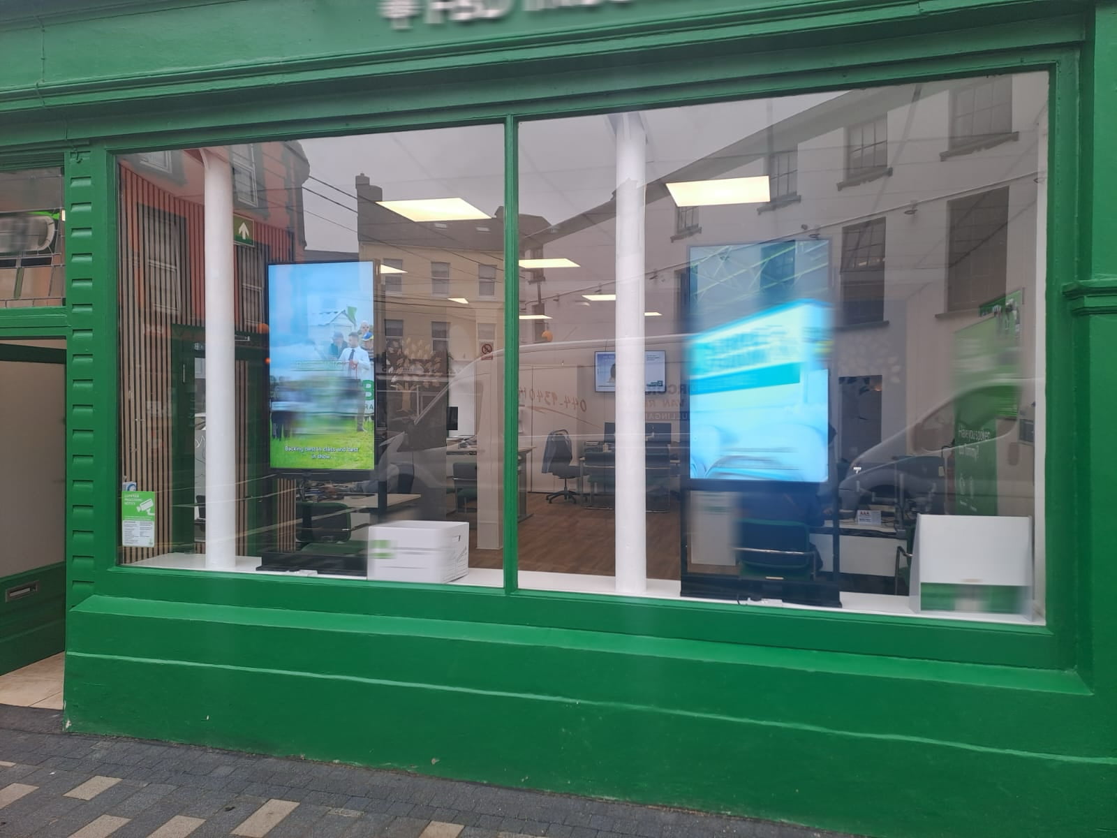 Portrait orientation window display digital signage screens showcasing advertising content in retail storefront glass window