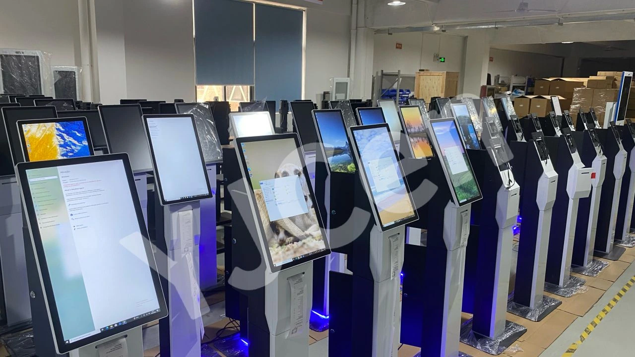 YJCEN self-ordering kiosks with screens powered on and printed receipts extending from their integrated printers.