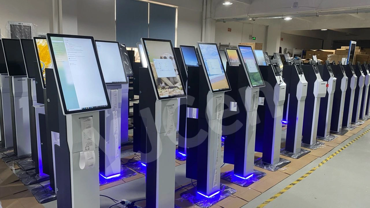 Rows of YJCEN self-ordering kiosks with printed receipts and blue LED-lit bases on the factory floor.