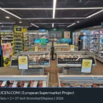 37-Zoll-Displays im Streifenformat auf maßgefertigten Bodenständern oberhalb von Kühlmöbeln in einem europäischen Supermarkt.