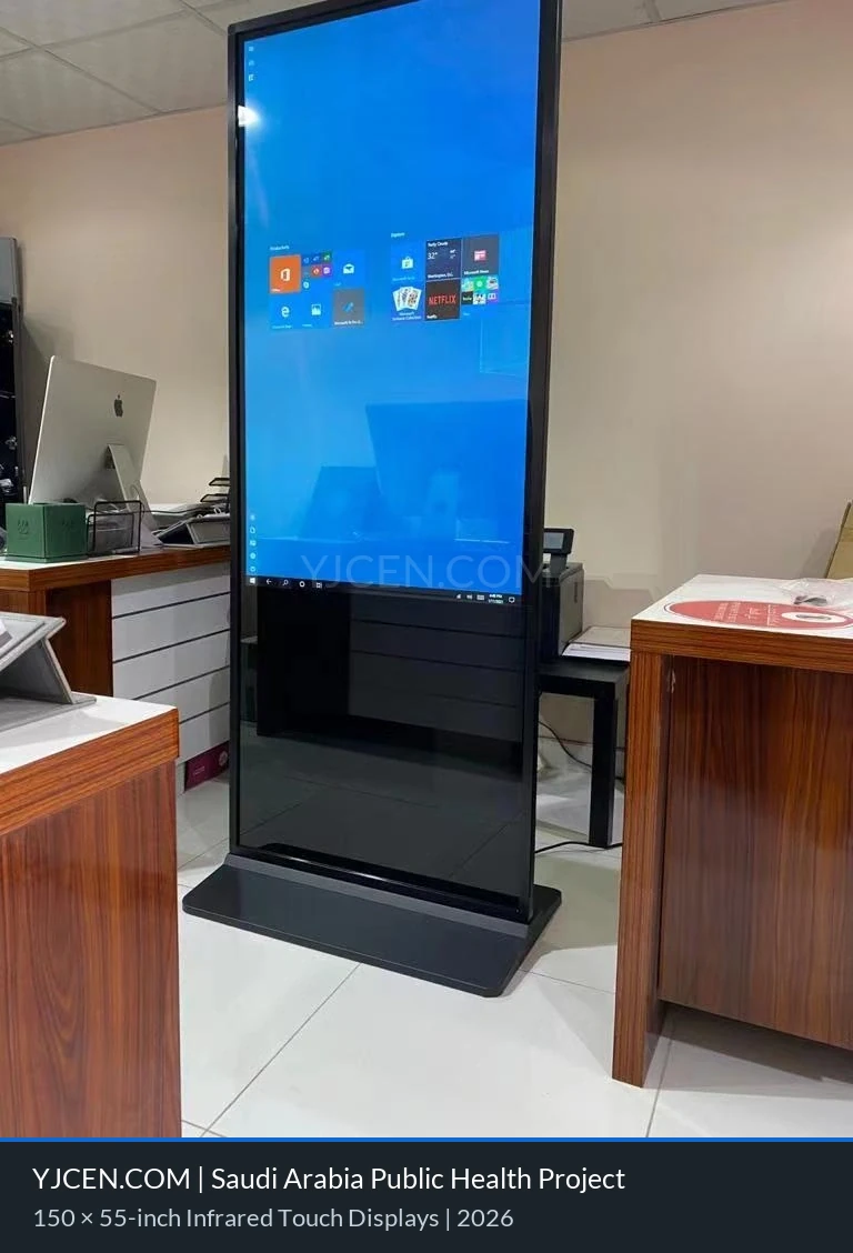 A YJCEN 55-inch floor-standing infrared touch display showing the Windows desktop for the Saudi Arabian public health project.