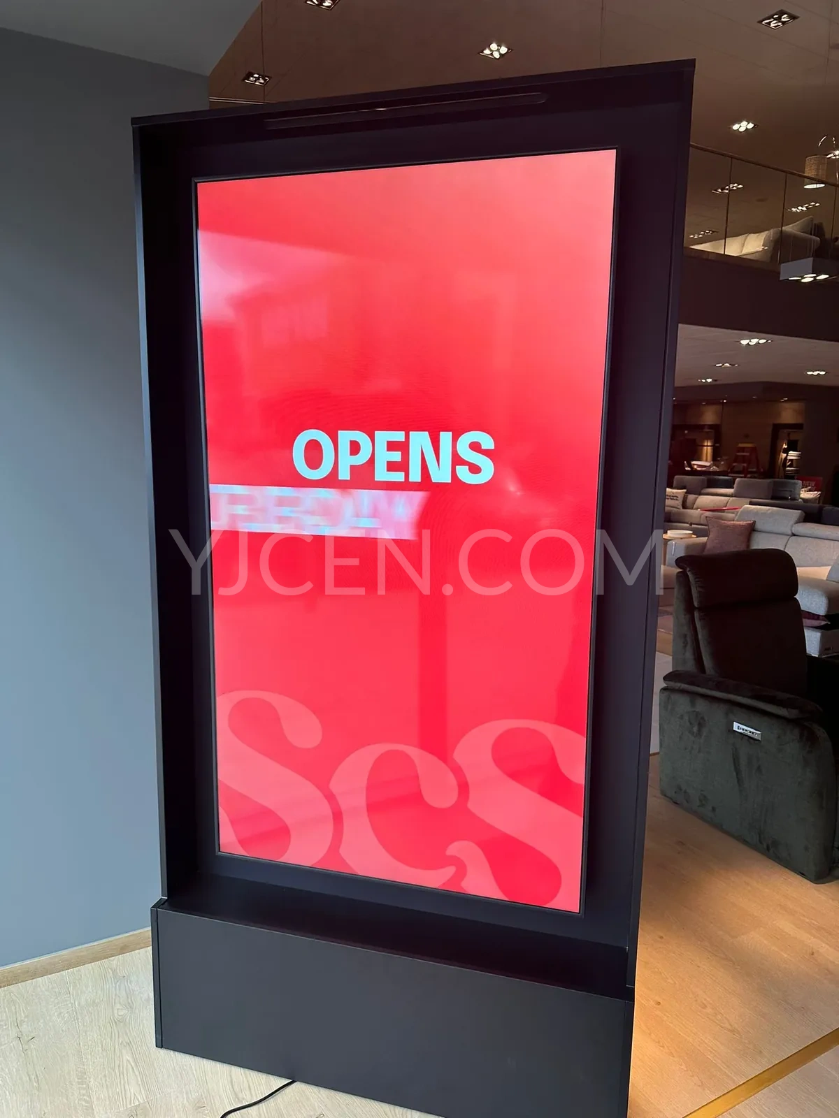 Écran YJCEN sur pied de 75 pouces diffusant un message promotionnel rouge dans un showroom de meubles.