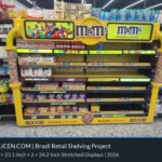 Vista frontale di uno scaffale giallo per dolciumi in Brasile con otto display LCD da 23,1 pollici sui bordi dei ripiani e due display superiori da 24,2 pollici.