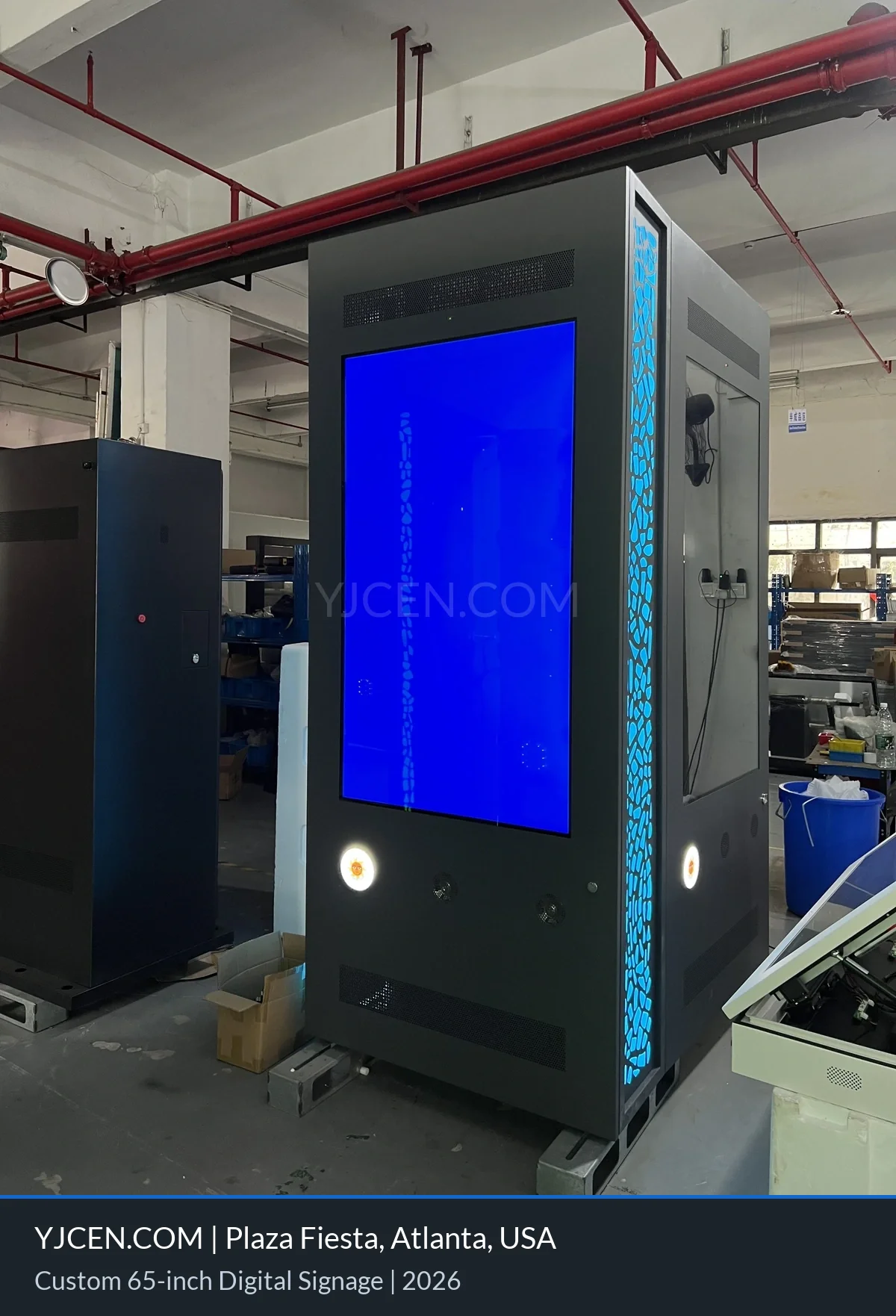 Unità digital signage bifacciale da 65 pollici su misura, con pannelli laterali illuminati in blu, durante i test in fabbrica.