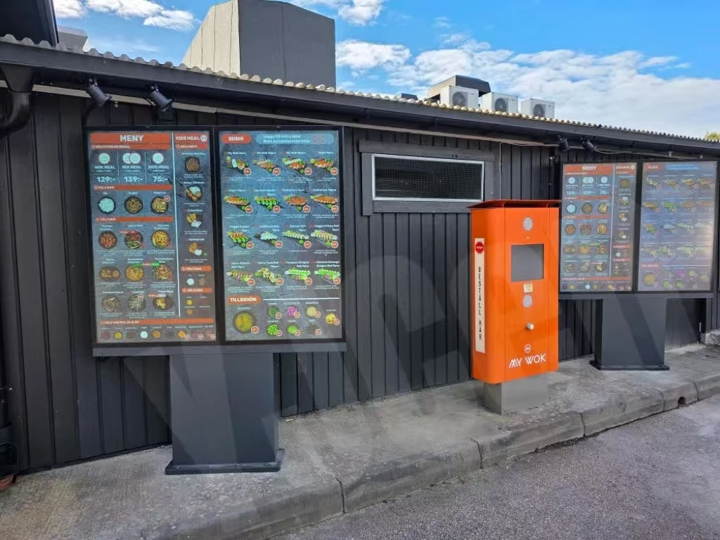 Digitale drive-thru-menudisplays van YJCEN buiten een restaurant in Europa, gefotografeerd in 2026.