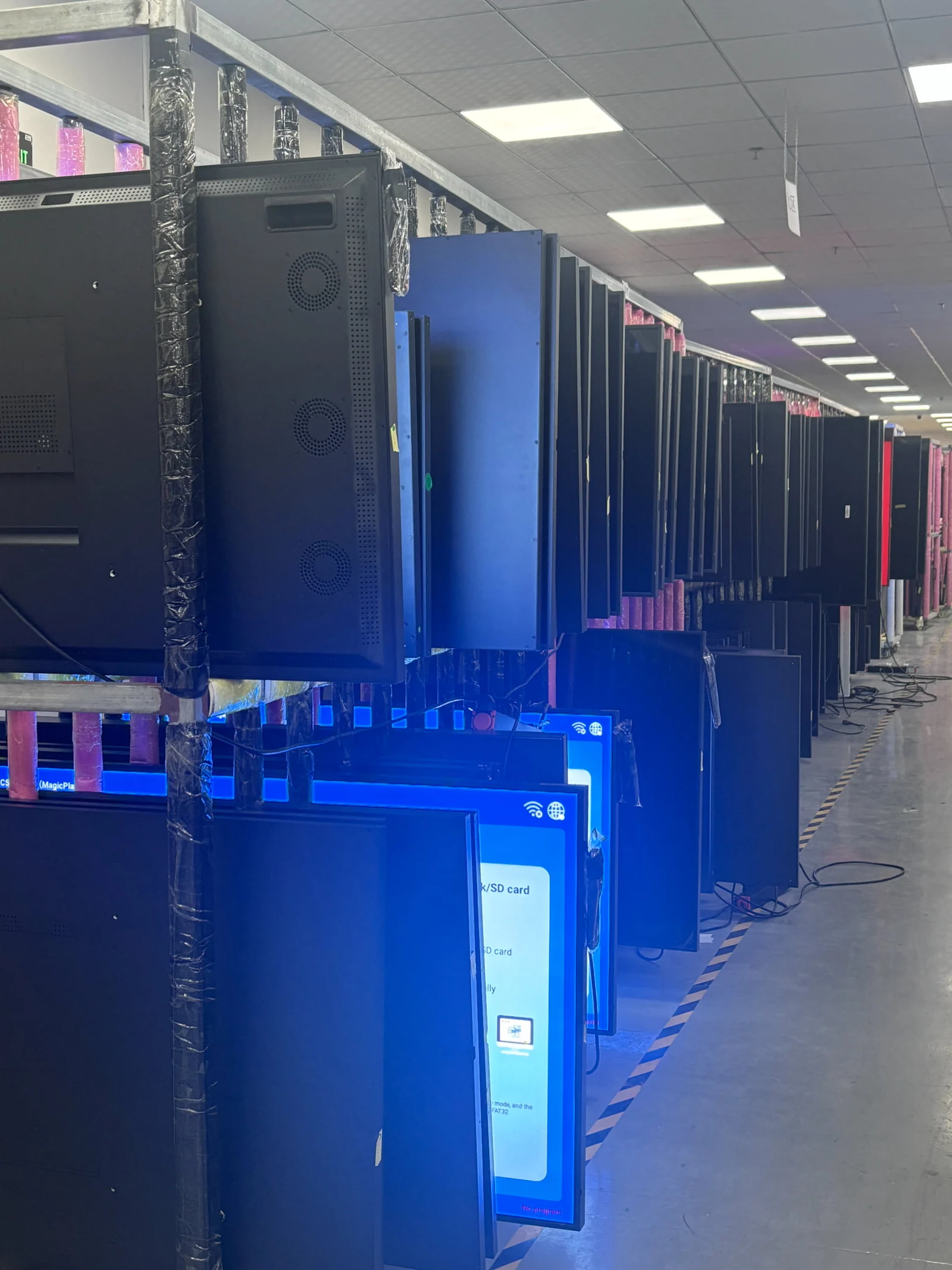 Rows of YJCEN commercial display hardware undergoing pre-shipment ageing tests.