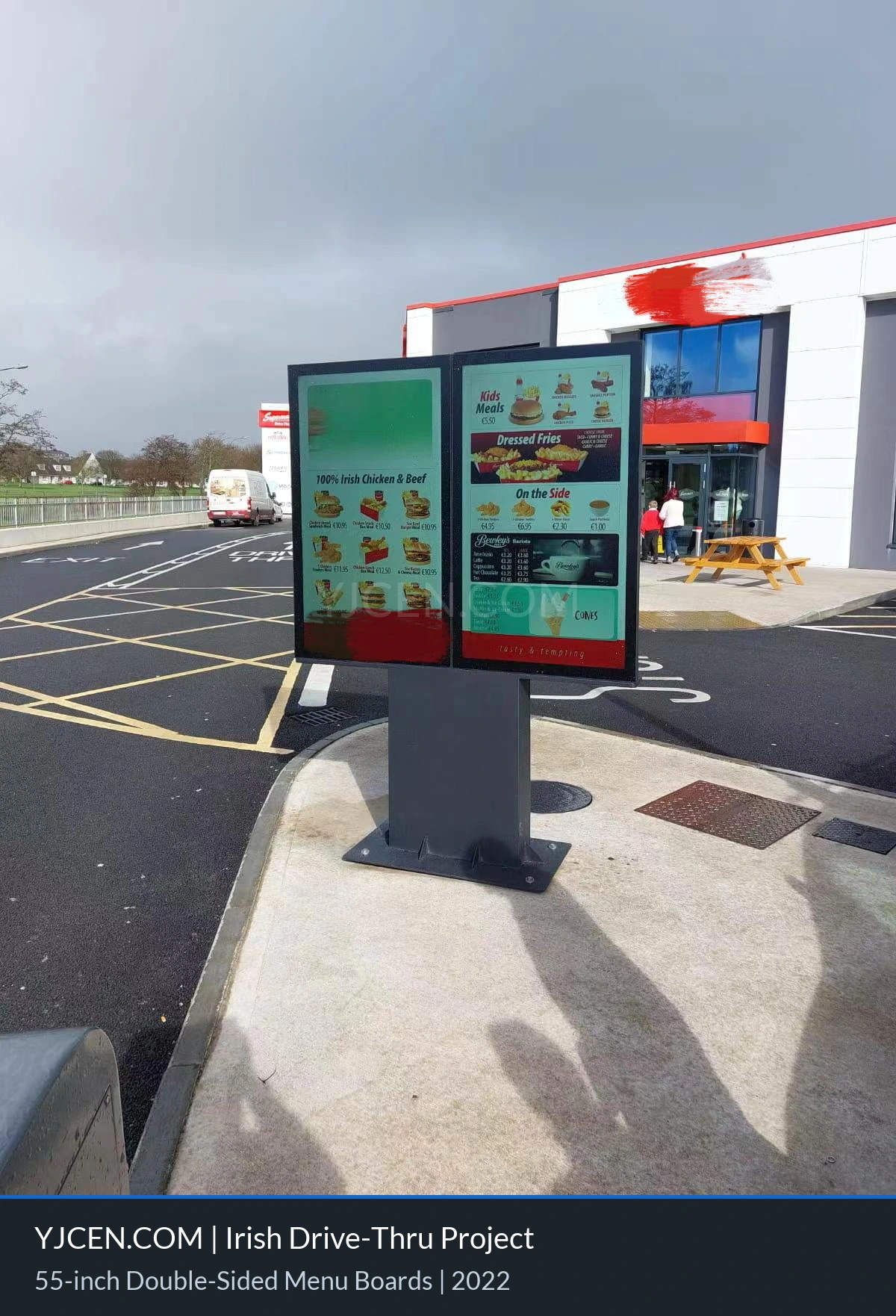 Doppelseitige digitale Outdoor-Menütafel am Drive-through eines Schnellrestaurants mit wettergeschütztem Touchdisplay für Speisen und Preise