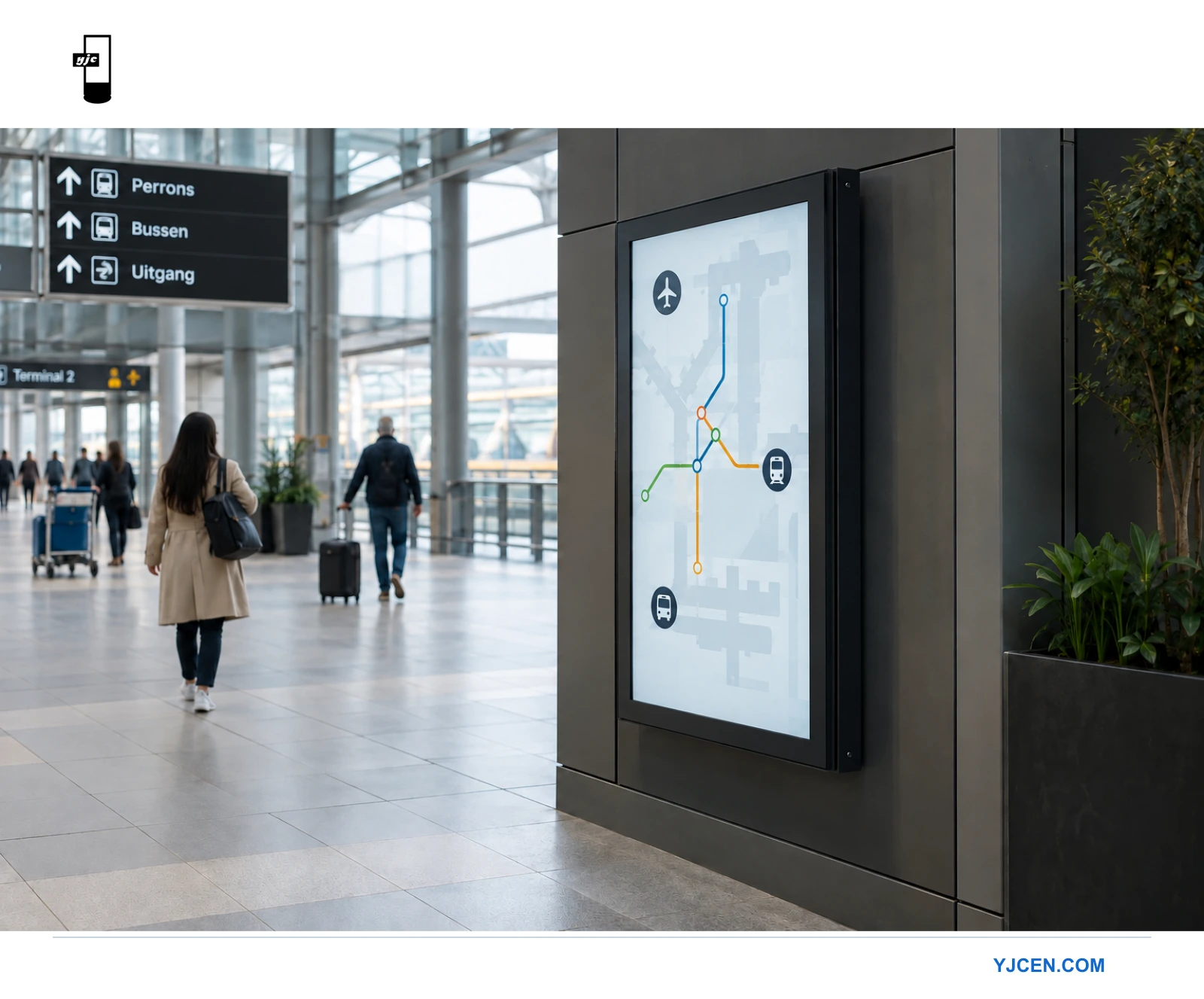 Een staand informatiedisplay met een donker metalen frame is naast een looproute in een stationshal gemonteerd.