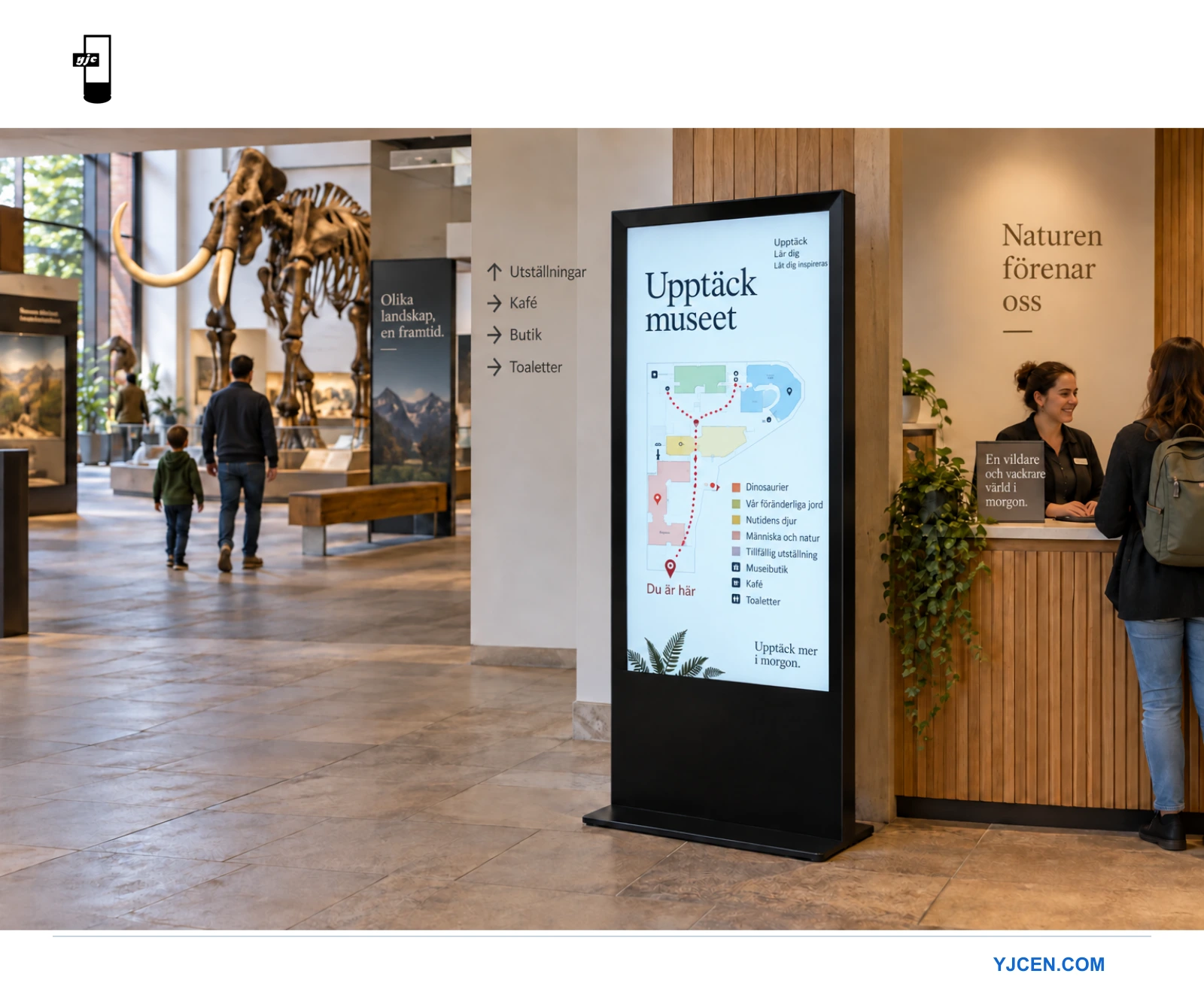 En golvstående skärm i stående format vid museets reception visar en besökskarta och rubriken Utforska museet.